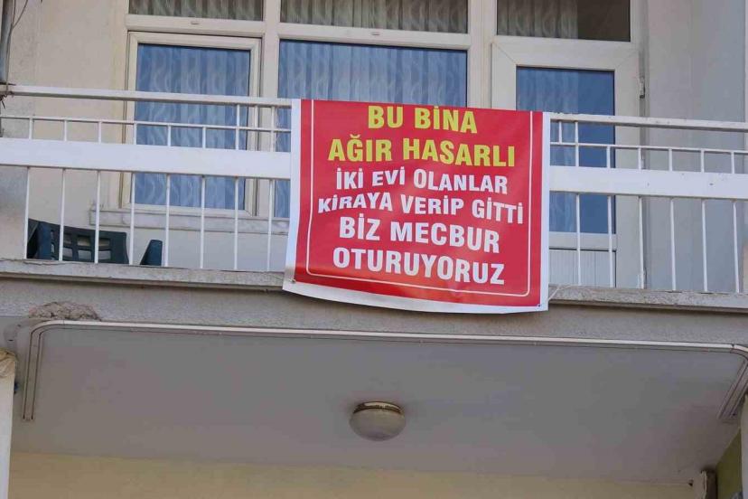 Ağır hasarlı pankartı asılan binayı görenler bir daha bakıyor