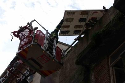 Çatıdan tehlikeli şekilde sarkan pano, itfaiye ekiplerince kaldırıldı