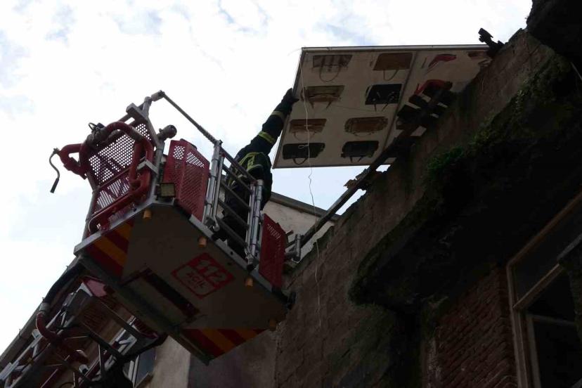 Çatıdan tehlikeli şekilde sarkan pano, itfaiye ekiplerince kaldırıldı
