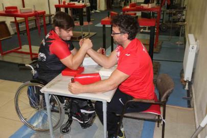 Aynı engele sahip olan öğrencisi ile bilek güreşi yapıyor