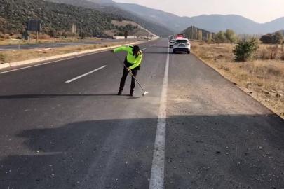 Trafik polisi cam kırıkları ve taş dökülen yolu fırçayla temizledi