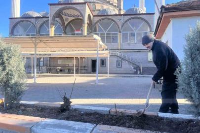 Gönüllü olarak cami önündeki çiçeklerin bakımını yapıyor