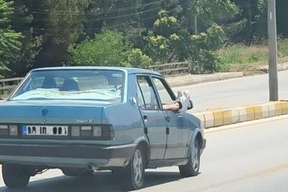 Ayaklarını camdan dışarı çıkartan yolcu trafiği riske attı