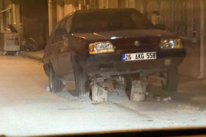 Sokak ortasonda kütükler üzerine bırakılan araç dikkat çekti