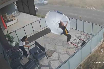 Fırtınada genç kızın şemsiyeyle imtihanı kameraya yansıdı