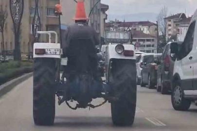 Bolu’da trafikte ilginç görüntü: Başına duba geçirip traktör sürdü